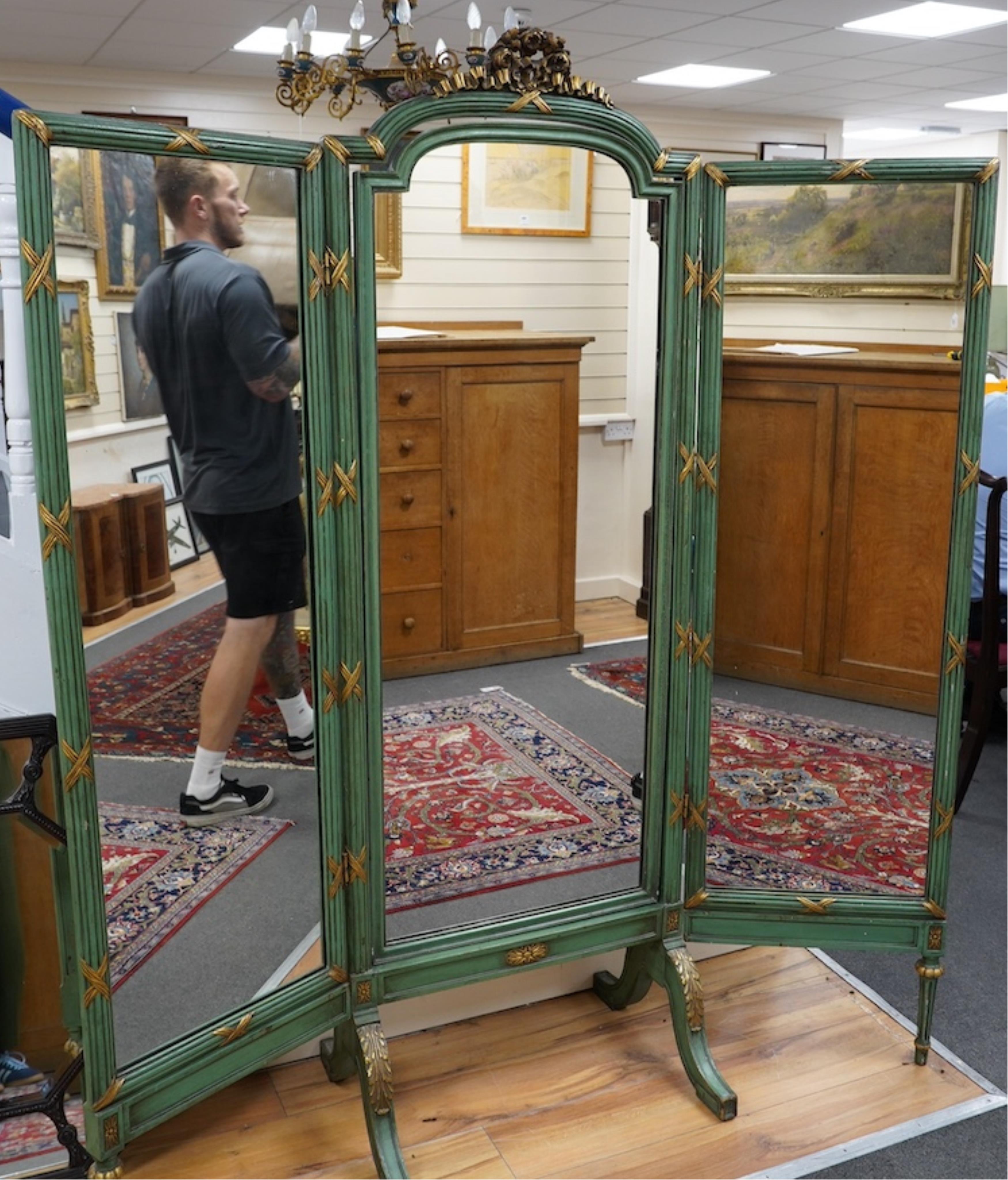 A Louis XVI style green painted and parcel gilt triple folding dressing mirror, width 160cm, height 185cm. Condition - fair